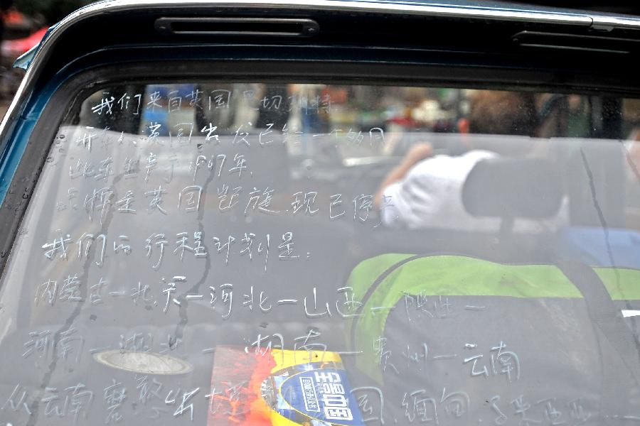 British Clive Raven has his traveling schedule written in Chinese on the car's rear windshield in Pingyao, north China's Shanxi Province, July 10, 2013. [Photo: Xinhua] 