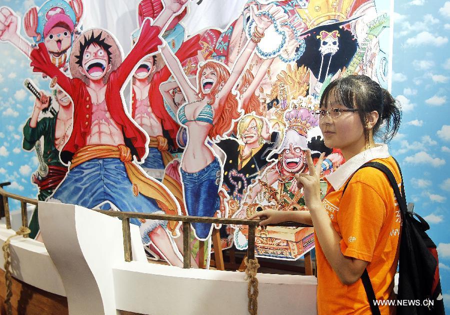 A visitor poses for photos at the 9th China International Comics Games Expo (CCG Expo) in Shanghai, east China, July 11, 2013. A total of 325 animation and game companies from at home and abroad took part in the five-day expo, which kicked off here on Thursday. (Xinhua/Ding Ting)