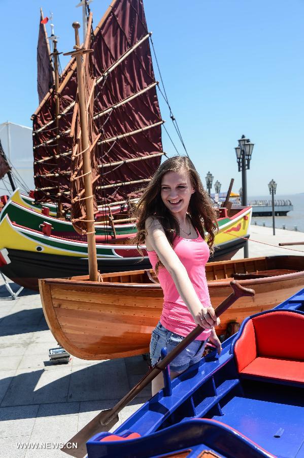 A model poses for photos during the 2013 China (Zhoushan archipelago) International Boat Show in the Putuo District of Zhoushan City, east China's Zhejiang Province, July 11, 2013. The show kicked off on Thursday. (Xinhua/Xu Yu)