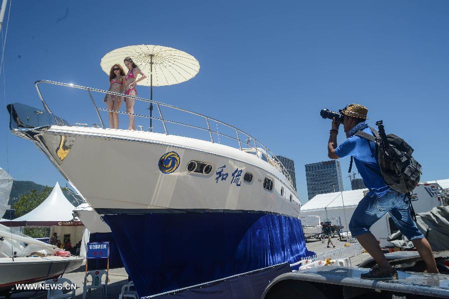 A photographer takes photos of two bikini models during the 2013 China (Zhoushan archipelago) International Boat Show in the Putuo District of Zhoushan City, east China's Zhejiang Province, July 11, 2013. The show kicked off on Thursday. (Xinhua/Xu Yu)