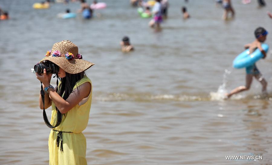 Tourists cool off on the beach in Shanghai, east China, July 11, 2013. The highest temperature in Shanghai reached 38.4 degrees Celsius on Thursday. (Xinhua/Zhuang Yi) 