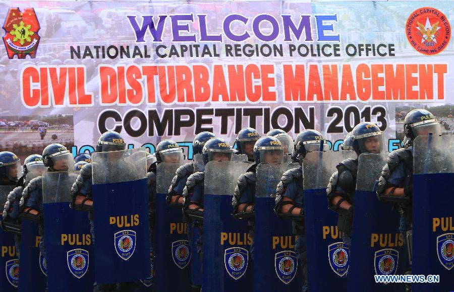 Members of the Civil Disturbance Management (CDM) of the Philippine National Police (PNP) march during the CDM Competition in Manila, the Philippines, July 11, 2013. The competition aimed to assess the effectiveness and efficiency of the CDM Units on the police operational procedures in handling civil disturbance. (Xinhua/Rouelle Umali)