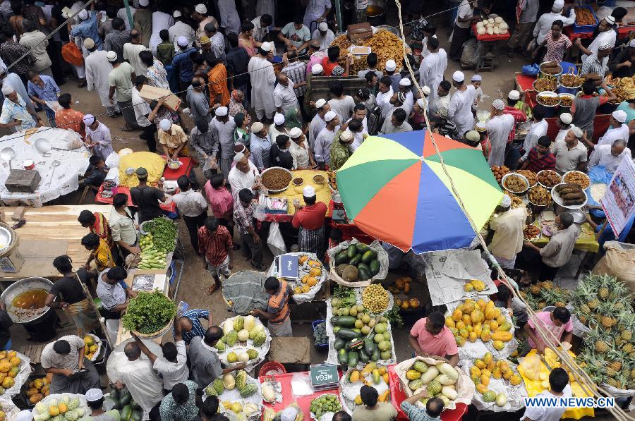 Bangladeshi Muslims buy ifter, food for breaking the daytime fast during the Islamic holy month of Ramadan, at a traditional ifter bazaar in Dhaka, Bangladesh, July 11, 2013. Ramadan is the Muslim month of fasting, during which Muslims refrain from eating, drinking, smoking from sunrise to sunset. (Xinhua/Shariful Islam)