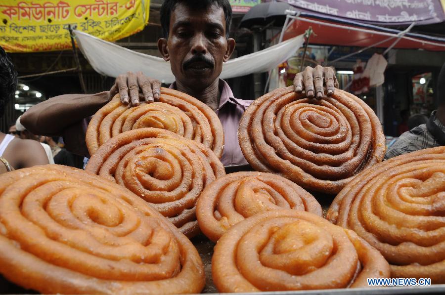 A vendor prepares ifter, food for breaking the daytime fast during the Islamic holy month of Ramadan, at a traditional ifter bazaar in Dhaka, Bangladesh, July 11, 2013. Ramadan is the Muslim month of fasting, during which Muslims refrain from eating, drinking, smoking from sunrise to sunset. (Xinhua/Shariful Islam)