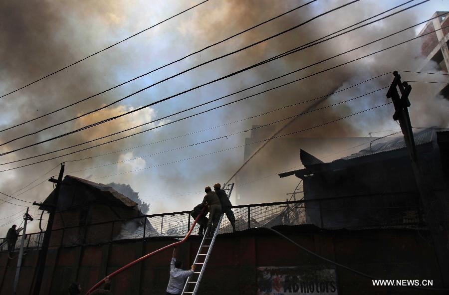 Firefighters try to distinguish the fire in a building on the premises of Civil Secretariat in Srinagar, the summer capital of Indian-controlled Kashmir, July 11, 2013. Massive fire broke out Thursday in a building on the premises of Civil Secretariat in Srinagar, the summer capital of Indian-controlled Kashmir, officials said. (Xinhua/Javed Dar)