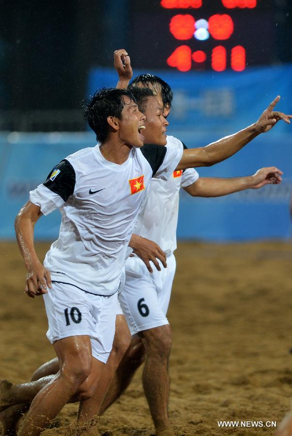 Nguyen Dinh Viet (L) of Vietnam celebrates after scoring during the men's beach soccer match against Australia at the 4th Asian Beach Games in Haiyang, east China's Shandong Province, July 11, 2013. Vietnam lost 2-7. (Xinhua/Zhu Zheng)