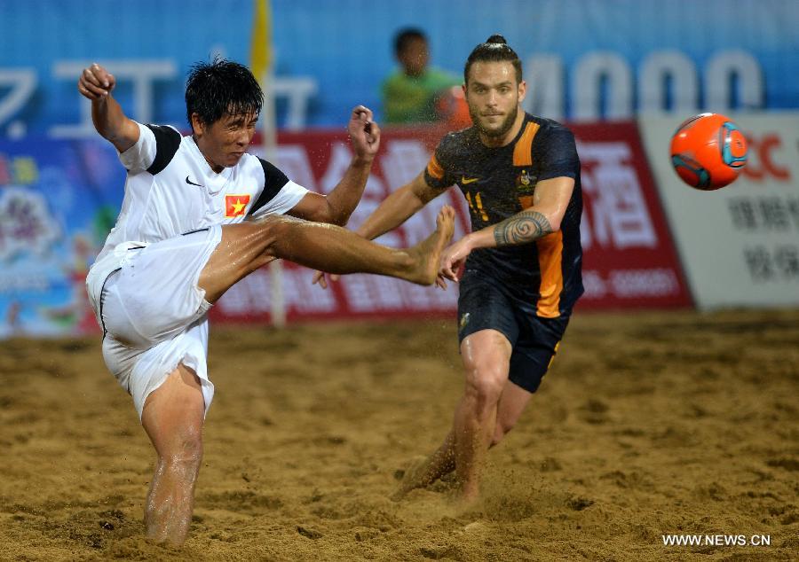 Nguyen Binh Phu (L) of Vietnam competes during the men's beach soccer match against Australia at the 4th Asian Beach Games in Haiyang, east China's Shandong Province, July 11, 2013. Vietnam lost 2-7. (Xinhua/Zhu Zheng)