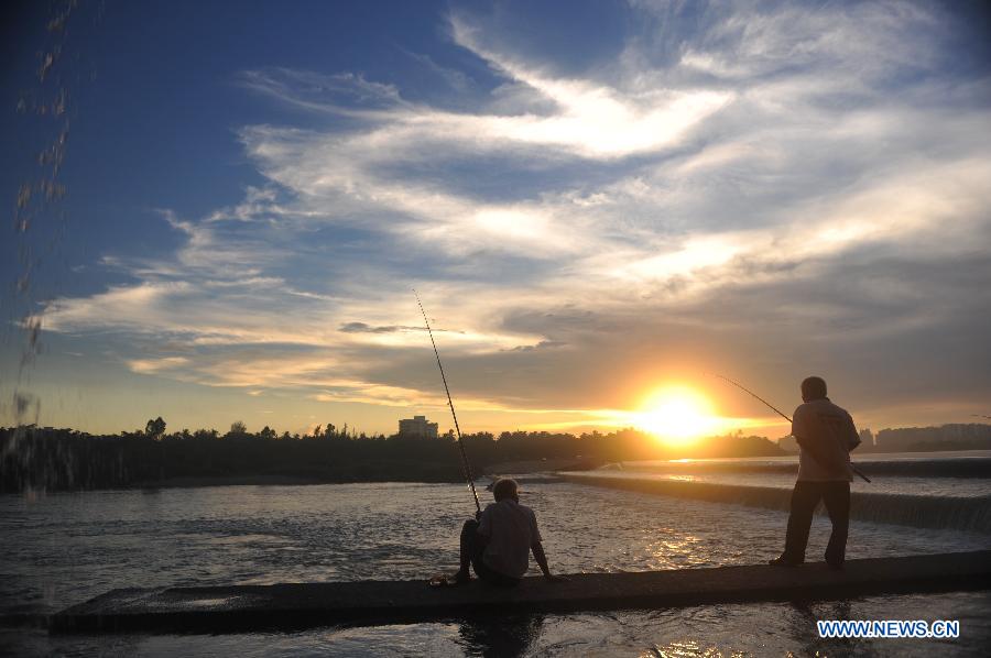 Local residents fish by the Wanquan River in Qionghai City, south China's Hainan Province, July 11, 2013. (Xinhua/Meng Zhongde)