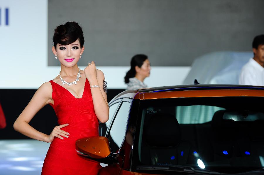 A model presents a vehicle at the 10th China Changchun International Automobile Expo in Changchun, capital of northeast China's Jilin Province, July 12, 2013. The ten-day expo kicked off here on Friday. (Xinhua/Xu Chang)