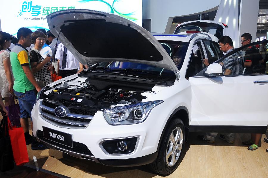 Visitors view a vehicle of China's First Automobile Works (FAW) at the 10th China Changchun International Automobile Expo in Changchun, capital of northeast China's Jilin Province, July 12, 2013. A total of 146 auto brands from 127 companies took part in the ten-day expo, which kicked off here on Friday. (Xinhua/Lin Hong)