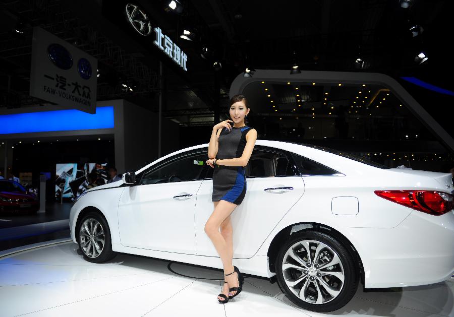 A model presents a vehicle at the 10th China Changchun International Automobile Expo in Changchun, capital of northeast China's Jilin Province, July 12, 2013. The ten-day expo kicked off here on Friday. (Xinhua/Xu Chang)