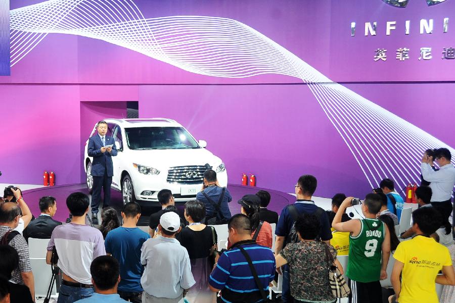 Visitors view an Infiniti vehicle at the 10th China Changchun International Automobile Expo in Changchun, capital of northeast China's Jilin Province, July 12, 2013. A total of 146 auto brands from 127 companies took part in the ten-day expo, which kicked off here on Friday. (Xinhua/Lin Hong)