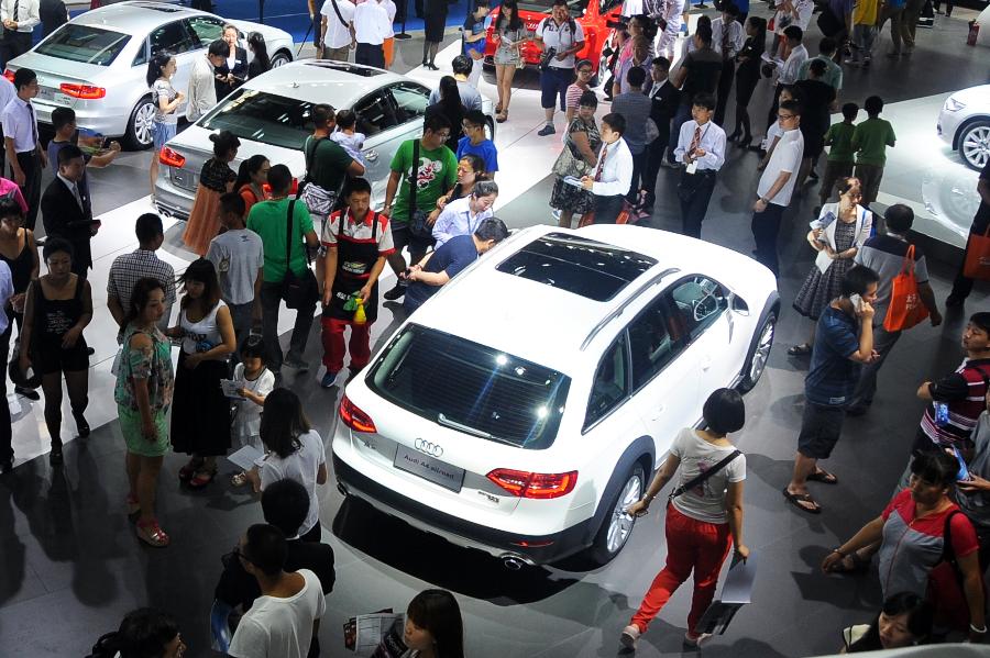 Visitors view an Audi vehicle at the 10th China Changchun International Automobile Expo in Changchun, capital of northeast China's Jilin Province, July 12, 2013. A total of 146 auto brands from 127 companies took part in the ten-day expo, which kicked off here on Friday. (Xinhua/Lin Hong)