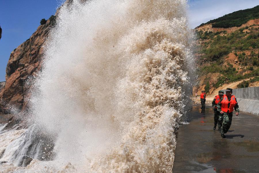 Soldiers carry out patrol duty at the seaside in Diaobang Harbour of Wenling City, east China's Zhejiang Province, July 12, 2013. The highest wave monitored off the southern Zhejiang coast reaches 5.5 meters high, as the Typhoon Soulik approaches. (Xinhua/Jia Ce) 