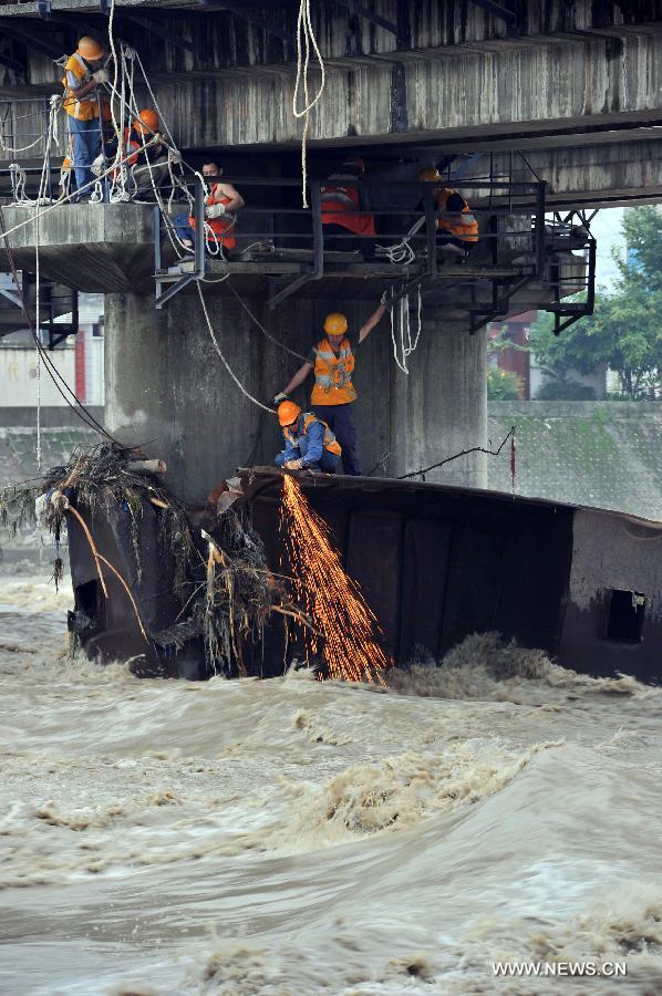 Rescue workers restore bridge's damage caused by flood in SW China 