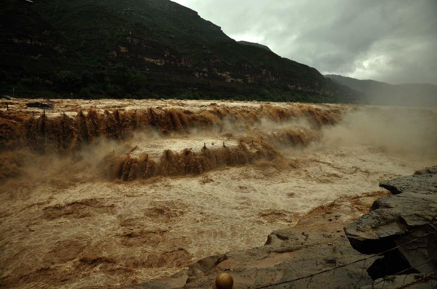 Photo taken on July 12, 2013 shows the Hukou Waterfall of the Yellow River from the site in Jixian County, north China's Shanxi Province. Triggered by non-stop heavy rainfall in the upper reaches, the rising water level of the Yellow River surged the Hukou Waterfall, attracting many visitors. (Xinhua/Lu Guiming) 