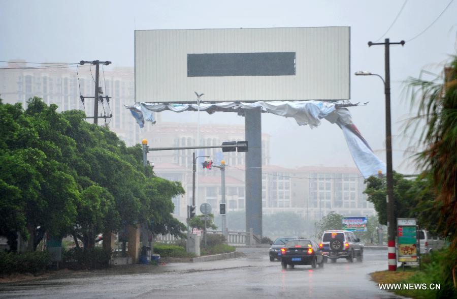 A billboard is damaged by the strong wind in the Luoyuan County, southeast China's Fujian Province, July 13, 2013. The local meteorological authority issued a red alert against typhoon as Typhoon Soulik approaches, bringing strong wind and rainstorms to the region. (Xinhua/Wei Peiquan) 