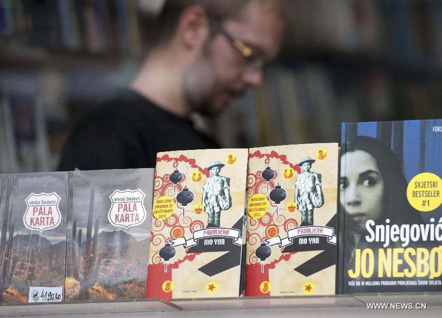 A man reads the Croatian edition of Chinese novelist Mo Yan's work "Change" in a bookstore in Zagreb, capital of Croatia, July 13, 2013. Croatian publishing company Fraktura published first translation of Mo Yan's work in Croatia. Mo Yan won the 2012 Nobel Prize for Literature. (Xinhua/Miso Lisanin) 