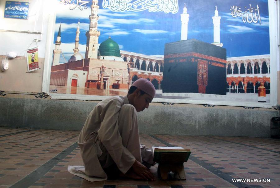 A Pakistani man reads holy Quran at a mosque during the holy month of Ramadan in northwest Pakistan's Peshawar, July 13, 2013. Muslims in Pakistan, mostly office workers, go to different mosques after work to attend religious activities during the fasting month of Ramadan. (Xinhua/Ahmad Sidique) 