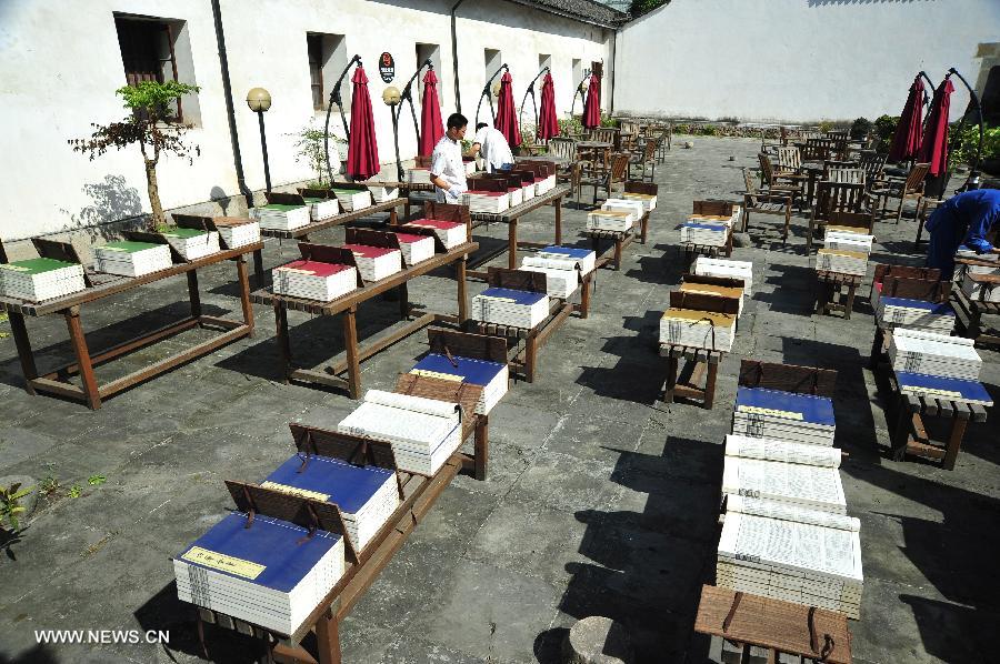 Staff members place books in the sun at the Yunhe Academy of Classical Learning in Hangzhou, capital of east China's Zhejiang Province, July 13, 2013. A book sunning festival was held at the academy to mark the tradition among ancient Chinese intellectuals to dry books in the sun on the sixth day of the sixth month of the lunar calendar, which falls on July 13 this year. (Xinhua/Xu Hui) 