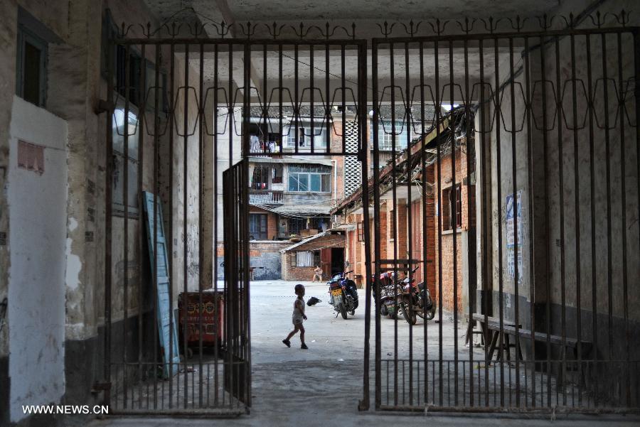 A boy plays behind a gate in the Miao Autonomous County of Chengbu, central China's Hunan Province, July 13, 2013. An ecology tourism festival is held here from July 12 to 14. (Xinhua/Cheng Tingting) 