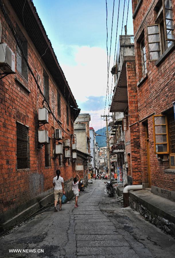 People walk in an old lane in the Miao Autonomous County of Chengbu, central China's Hunan Province, July 13, 2013. An ecology tourism festival is held here from July 12 to 14. (Xinhua/Cheng Tingting)