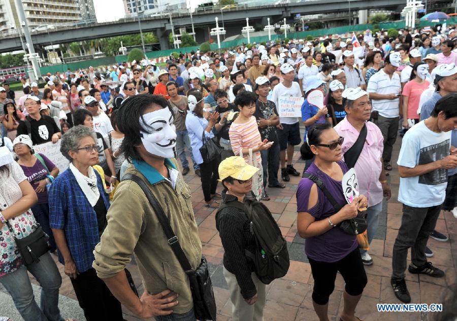 Protesters wearing masks attend a rally in front of Lumpini Park in Bangkok, capital of Thailand, July 14, 2013. A number of anti-government protesters rallied in Bangkok and other ten more provinces in Thailand. (Xinhua/Gao Jianjun)