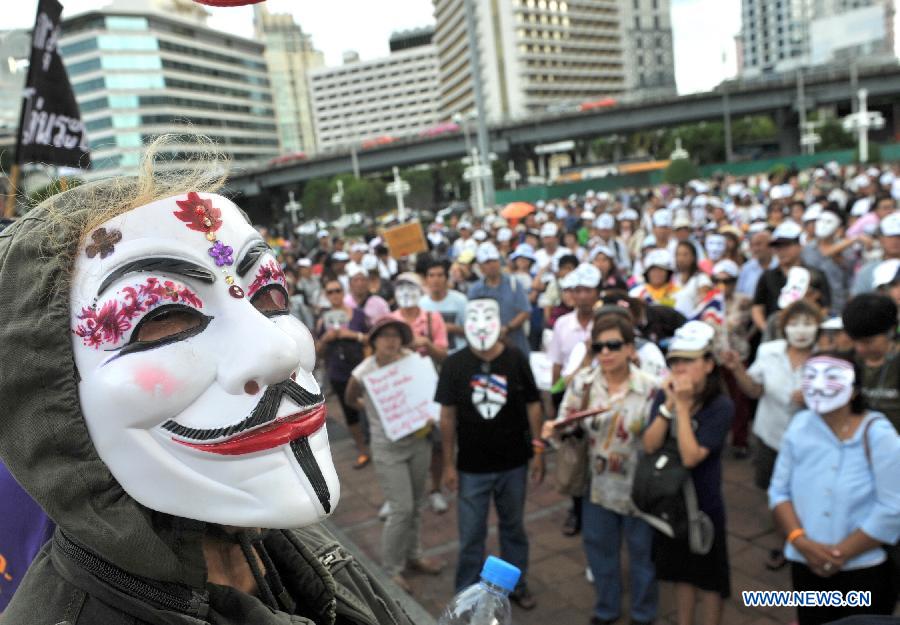 Protesters wearing masks attend a rally in front of Lumpini Park in Bangkok, capital of Thailand, July 14, 2013. A number of anti-government protesters rallied in Bangkok and other ten more provinces in Thailand. (Xinhua/Gao Jianjun)