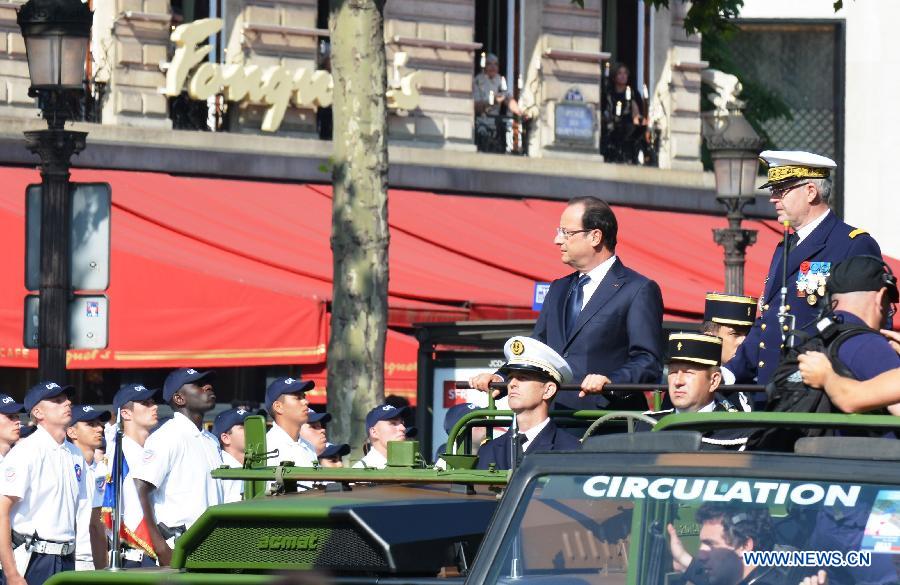 French President Francois Hollande and French Army Chief of Staff Admiral Edouard Guillaud (R) review the troops during the Bastille Day military parade in Paris, France, on July 14, 2013. (Xinhua/Li Genxing)