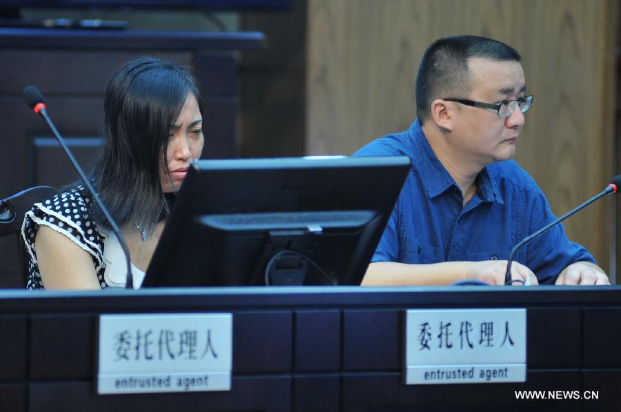 Tang Hui (L), mother of a young rape victim who sued a local authority for putting her into a labor camp, attends the court hearing in The Hunan Provincial People's High Court in Changsha, capital of central China's Hunan Province, July 15, 2013. The Hunan Provincial People's High Court on Monday ordered the Yongzhou municipal re-education through labor commission to pay Tang Hui 2,941 yuan (478 U.S. dollars) in compensation for infringing upon her personal freedom and causing mental damages. The 40-year-old mother appealed to the high court in April after the Yongzhou Intermediate People's Court denied her request for an apology and compensation from the re-education through labor commission. Tang was put into the labor camp after she publicly petitioned for harsher punishments for those found guilty of raping her daughter and forcing her into prostitution. (Xinhua/Long Hongtao) 