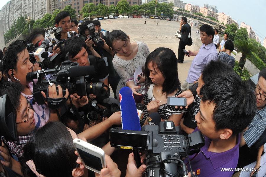 Tang Hui, mother of a young rape victim who sued a local authority for putting her into a labor camp, receives interview after the final ruling outside The Hunan Provincial People's High Court in Changsha, capital of central China's Hunan Province, July 15, 2013. The Hunan Provincial People's High Court on Monday ordered the Yongzhou municipal re-education through labor commission to pay Tang Hui 2,941 yuan (478 U.S. dollars) in compensation for infringing upon her personal freedom and causing mental damages. The 40-year-old mother appealed to the high court in April after the Yongzhou Intermediate People's Court denied her request for an apology and compensation from the re-education through labor commission. Tang was put into the labor camp after she publicly petitioned for harsher punishments for those found guilty of raping her daughter and forcing her into prostitution. (Xinhua/Long Hongtao) 