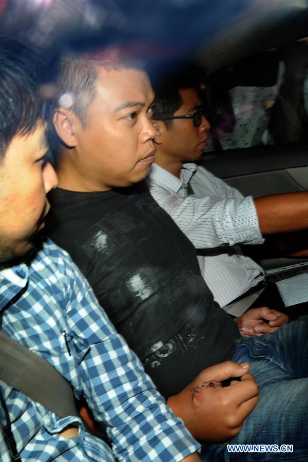 Police officer Iskandar bin Rahmat (C), Kovan double murder suspect, arrives at the Singapore Subordinate Courts to face charges in Singapore, July 15, 2013. (Xinhua/Then Chih Wey)