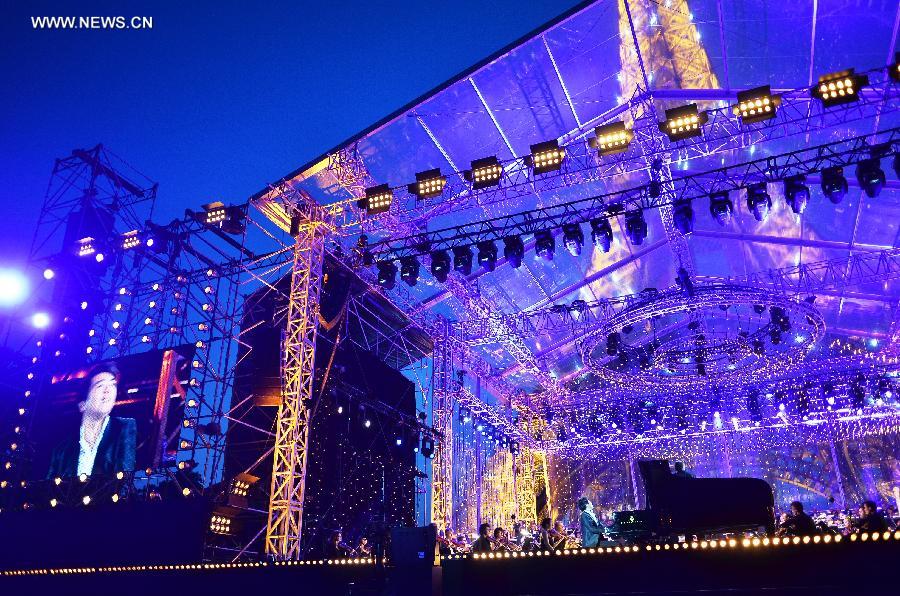 Chinese pianist Lang Lang plays piano during the national day concert held in Paris, France, on July 14, 2013. (Xinhua/Li Genxing)