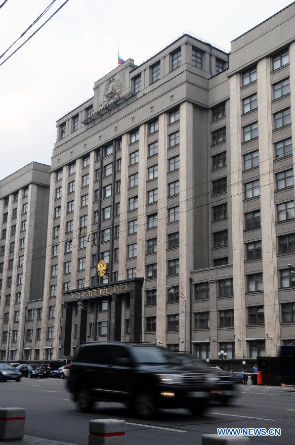 Cars drive past the state duma building as the Russian flag on the building flies at half mast mourning the fatal crash on July 13 in Moscow, Russia, July 15, 2013. 18 people were killed and other 61 injured after a truck carrying concrete ran into a passenger bus in an outlying area of Moscow. Moscow government declared a mourning day on Monday.(Xinhua)