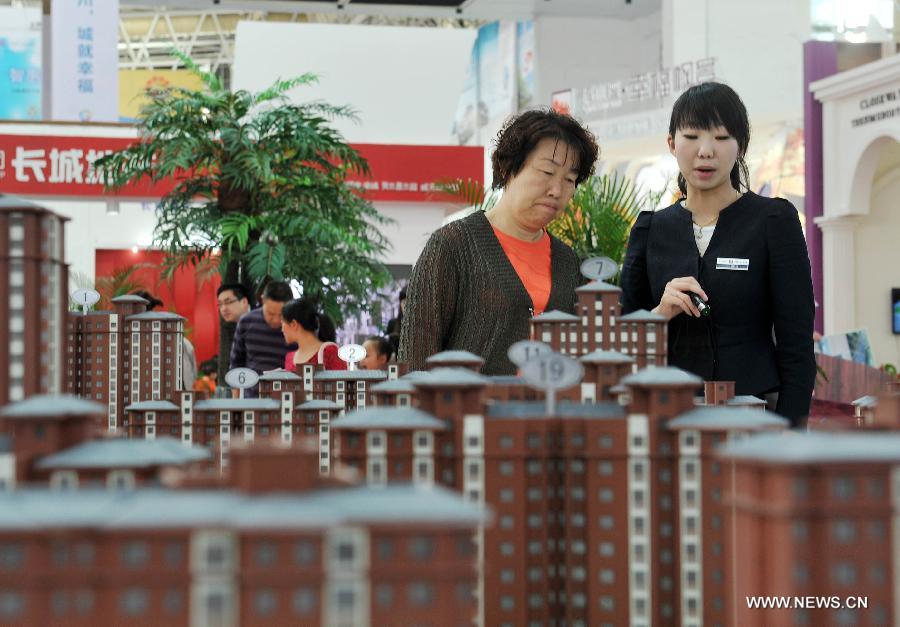 Photo taken on May 1, 2013 shows a visitor consulting the information of commercial residential buildings which are on sale in Yinchuan City, Ningxia Hui Autonomous Region. China's gross domestic product (GDP) totaled 24.8 trillion yuan (4 trillion U.S. dollars) in the first half of 2013, with the growth at 7.6 percent, which is in line with market expectations and was above the government's full-year target of 7.5 percent, data from China's National Bureau of Statistics (NBS) showed on July 15, 2013. (Xinhua/Peng Zhaozhi)