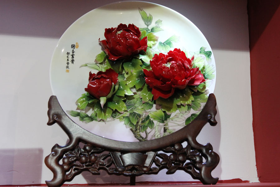 Porcelain artwork featuring the pattern of peony flowers is shown at the 2013 China International Consumer Products Exhibition. (CRIENGLISH.com/Wang Wei)