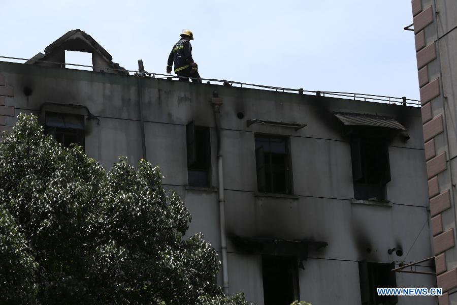 A fireman works on a residential building at Yangpu District in Shanghai, east China, July 16, 2013. A fire broke out at the five-storey building early Tuesday, leaving two people killed. Local fire department took one hour to douse the fire. (Xinhua/Yang Shichao) 