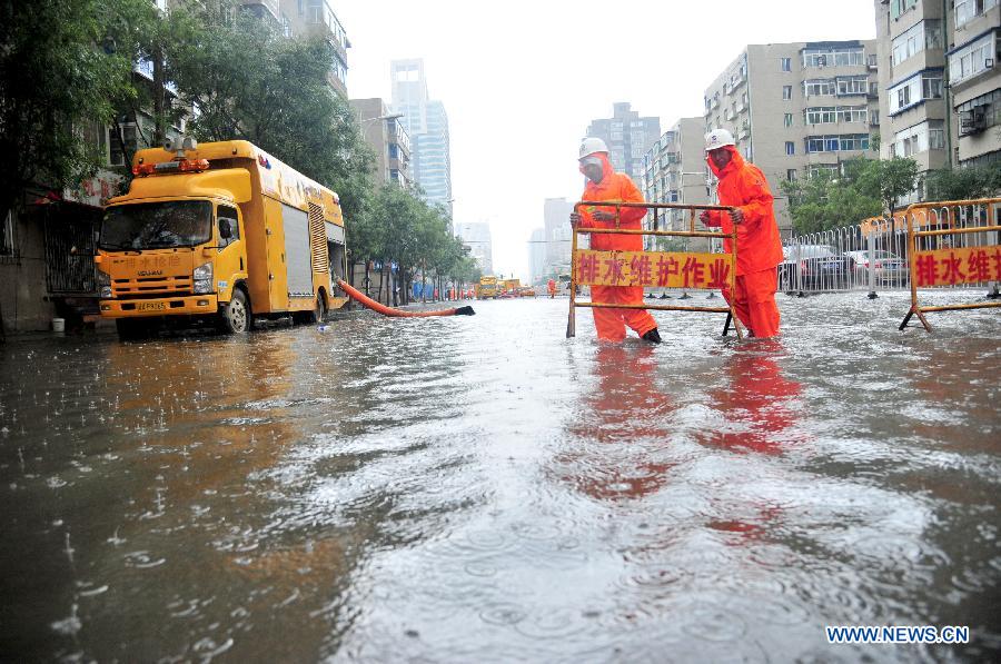 Workers drain water on a flooded road in Shenyang, capital of northeast China's Liaoning Province, July 16, 2013. Shenyang was hit by a rainstorm on Tuesday. (Xinhua/Zhang Wenkui) 