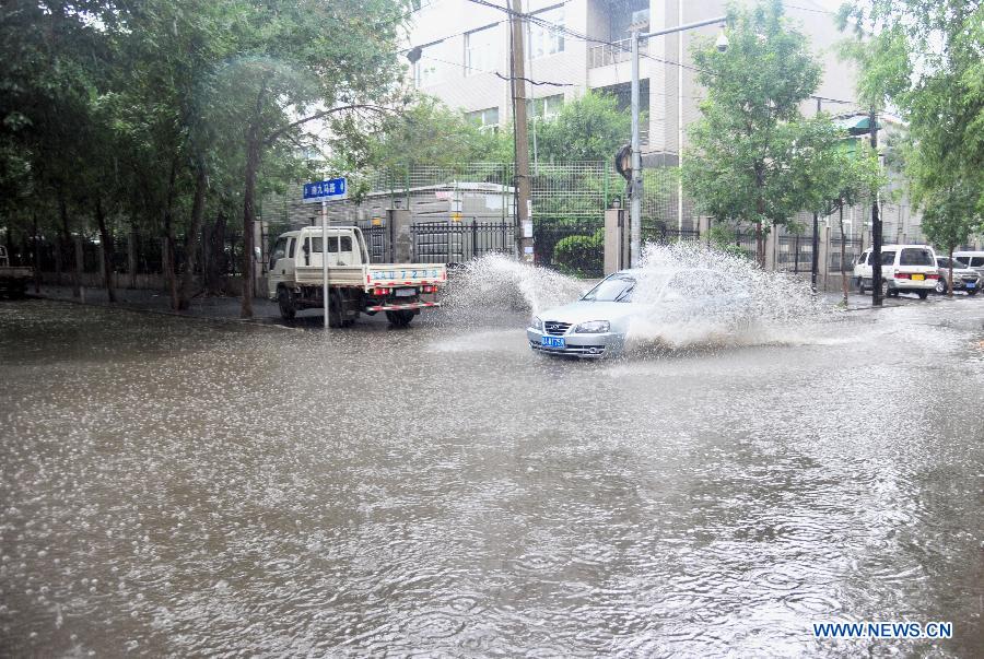 A car drives on a flooded road in Shenyang, capital of northeast China's Liaoning Province, July 16, 2013. Shenyang was hit by a rainstorm on Tuesday. (Xinhua/Zhang Wenkui) 