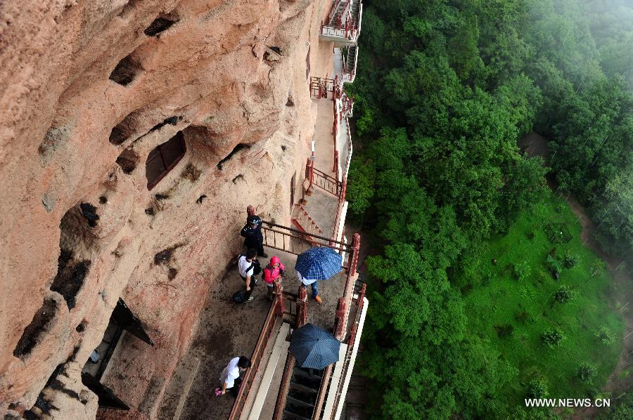 People visit the Maiji Mountain Grottoes in Tianshui, northwest China's Gansu Province, July 15, 2013. After protection and preparation, the Maiji Mountain Grottoes, the fourth largest grottoes in China and known as the "Oriental Sculpture Museum", has been ready for the application for status on the World Heritage List in 2014, as a part of the application program of the 2,000-year-old Silk Road which China works with Kazakstan and Kyrgyzstan and was officially submitted to the United Nations Educational, Scientific and Cultural Organization (UNESCO) in January of 2013. China has altogether 22 historical sites in this application program, including seven in Xinjiang, five in Gansu, six in Shaanxi and four in Henan. (Xinhua/Nie Jianjiang) 