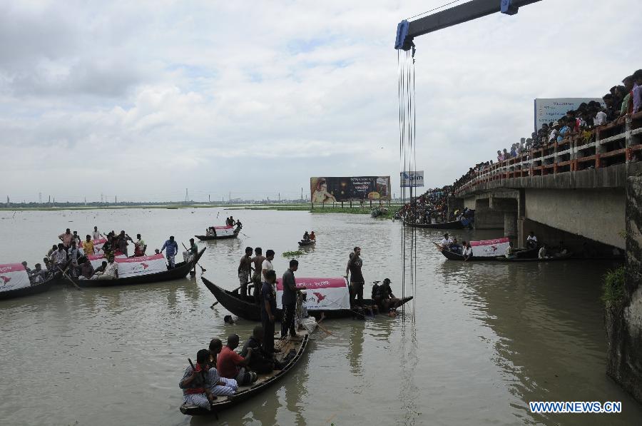 Rescuers search for victims in the Turag river after a road accident at Ashuria on the outskirts of Dhaka, capital of Bangladesh, July 16, 2013. A passenger bus fell in to a river on the outskirts of Bangladesh's capital Dhaka Tuesday morning, leaving 5 people dead and 19 others missing, fire service officials said. (Xinhua/Shariful Islam)