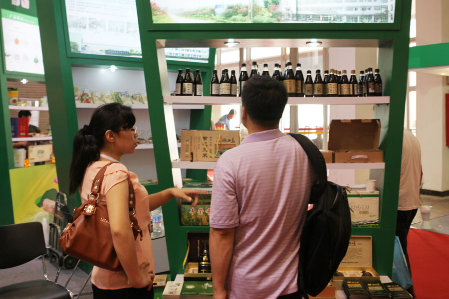 Visitors view products from a green food company which sells lotus roots products in east China's Jiangsu province, at the 2013 China International Consumer Products Exhibition. [Photo: CRIENGLISH.com/Wang Wei] 