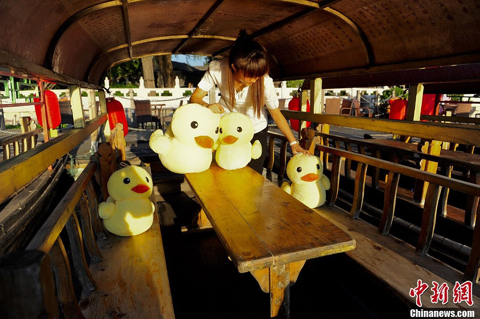 Little rubber ducks are “invited” to board the boats in Beijing's Shichahai Lake, July 16, 2013. The recent news saying that the Rubber Duck will visit Beijing this September has attracted Robber Duck fans’ attention. As one of the candidate places to host the Robber Duck, Shichahai Lake organized some events to welcome the Robber Duck. People who book group boat tickets online and take photos with little rubber ducks on the boat will get an authentic Rubber Duck doll. (Photo/Chinanews)