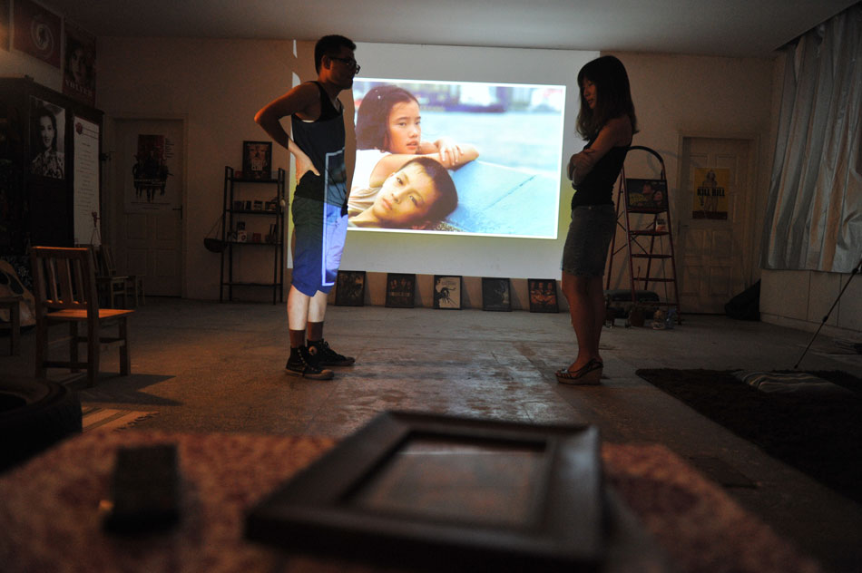 A young couple stands in a salon transformed from an abandoned storage for film and music lovers, east China’s Nanjing city, July 6, 2013. (Xinhua/Shen Peng)