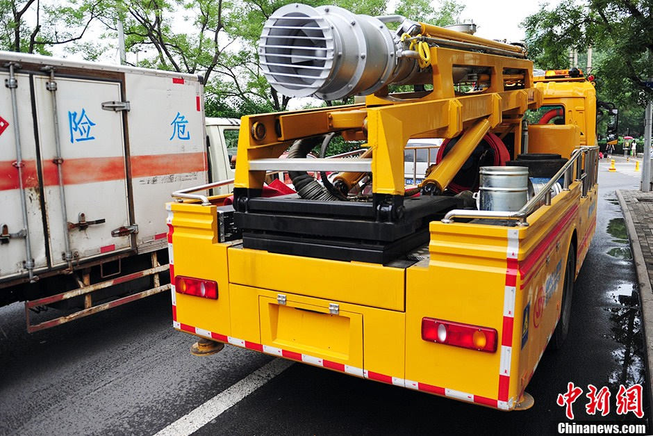 Emergency rescue vehicles, such as the highly-effective drainage vehicles and electricity-generating vehicles are stationed near the Guangqumen Bridge in Beijing, capital of China, on July 9. The capital city's flood control office together with other government authorities has designed emergency plans to prevent heavy rain-induced accidents as the city enters its flood season. (Photo from Chinanews.com/Translated by Zhang Junmian) (Source: China.org.cn)