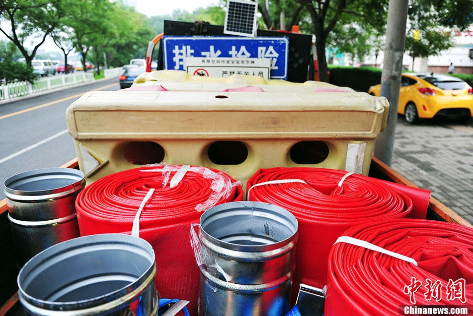 Emergency rescue vehicles, such as the highly-effective drainage vehicles and electricity-generating vehicles are stationed near the Guangqumen Bridge in Beijing, capital of China, on July 9. The capital city's flood control office together with other government authorities has designed emergency plans to prevent heavy rain-induced accidents as the city enters its flood season. (Photo from Chinanews.com/Translated by Zhang Junmian) (Source: China.org.cn)