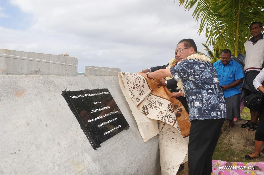 Chinese Ambassador to Fiji Huang Yong (front) and Inia Seruiratu, Fiji' minister for rural and maritime development, jointly commission the Kiuva village sea wall at Kiuva village, Tailevu province, Fiji, July 17, 2013. China on Wednesday donated a sea wall to Fiji, which became an example of the Fijian government's commitment to addressing sea level rise and protecting villages along coastal areas. (Xinhua/Michael Yang)