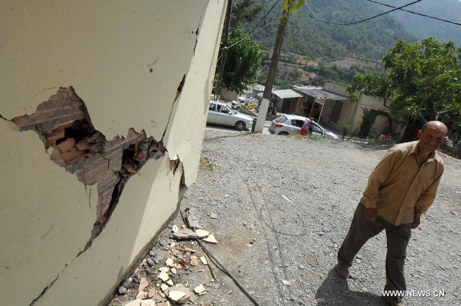 A man goes by a house damaged in the earthquake shaking the locality of Hammam Melouene, in the province of Blida, 45 km south of Algiers, in Algeria, on July 17, 2013. An earthquake measuring 5.1 on the Richter scale on Wednesday hit Algeria's northern province of Blida, some 45 km south of capital Algiers, injuring 11 people, official APS news agency reported. (Xinhua/Mohamed Kadri)