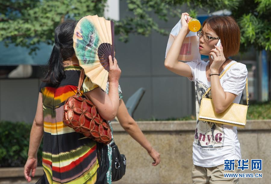 People use different objects to block the sunshine in Jiangbei District of Chongqing, southwest China, July 11, 2013. The temperature in Chongqing reached 37 degrees Celsius on the day. The weather station of Chongqing issued an orange warning of high temperature.(Photo/Xinhua)