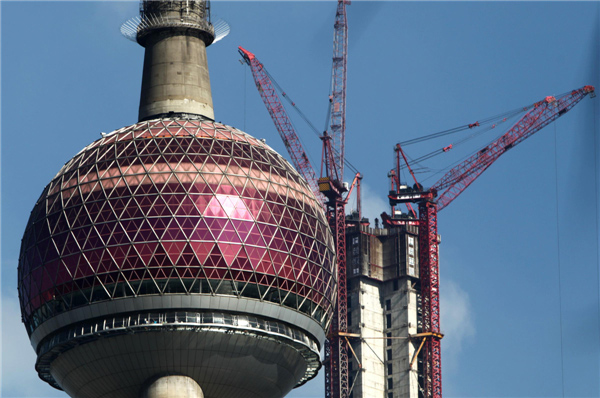 Shanghai Tower, China's tallest building, is going up beside the iconic Oriental Pearl Tower in the Lujiazui finance and trade district in Shanghai's Pudong area, July 17, 2013. The structure will be capped soon with a spire, which will bring the dragon-shaped building to a height of 632 meters, dwarfing the 492-meter Shanghai World Financial Center and 421-meter Jinmao Tower. The building will be finished and open by 2015. (Photo/Xinhua)